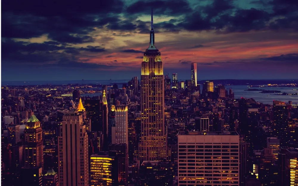 Things to Do in NYC 4 The Empire State Building lit up above the Manhattan skyline at dusk