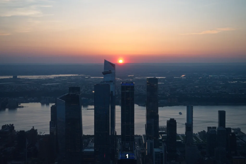 Empire State Building Tickets: Real Prices, the $5 Fee, and Where to Buy 4 Sunset seen from the Empire State Building observation deck, with the Hudson Yards towers and the Hudson River in the foreground