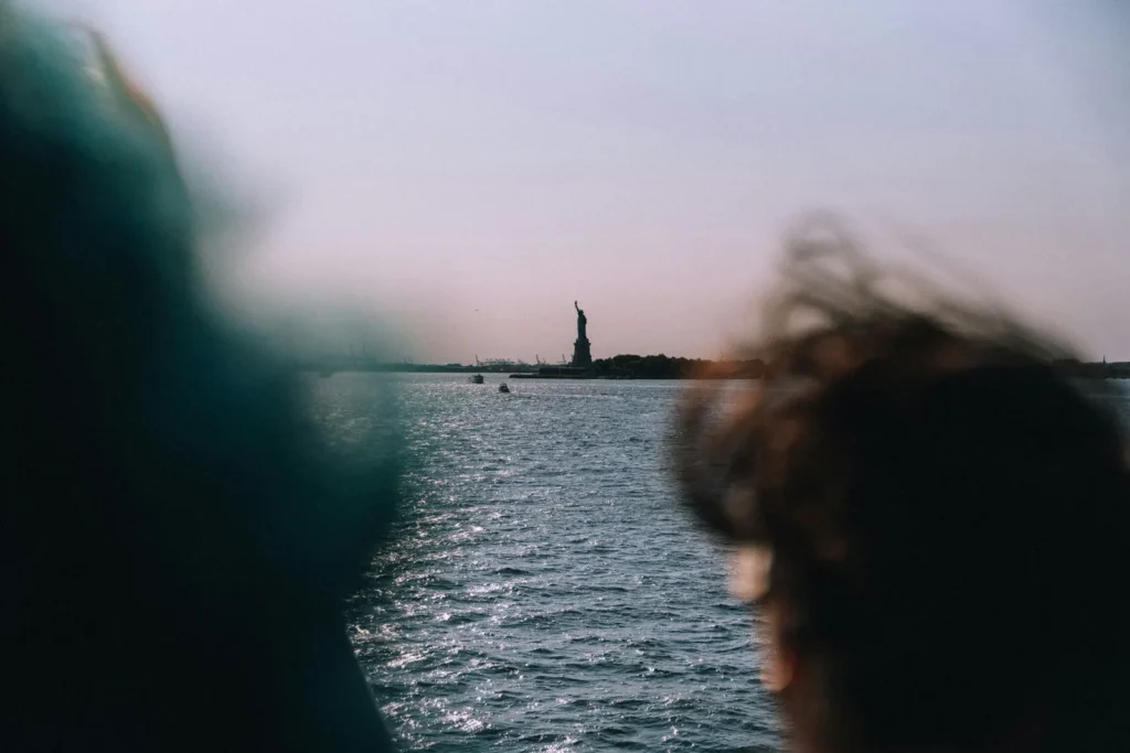 Staten Island Ferry: The Free Ride Past the Statue of Liberty 3 The Statue of Liberty seen at a distance across New York Harbor, framed between two ferry passengers
