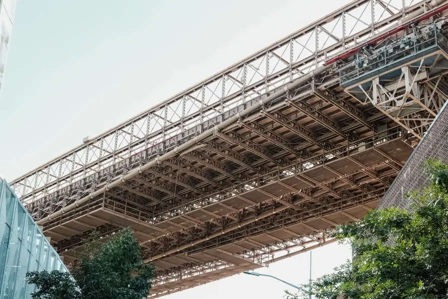 The High Line NYC: Complete Visitor Guide (Free, Hours & Tips) 2 View from below of the High Line’s original steel railway viaduct showing the riveted beams and lattice framework built in the 1930s in Manhattan